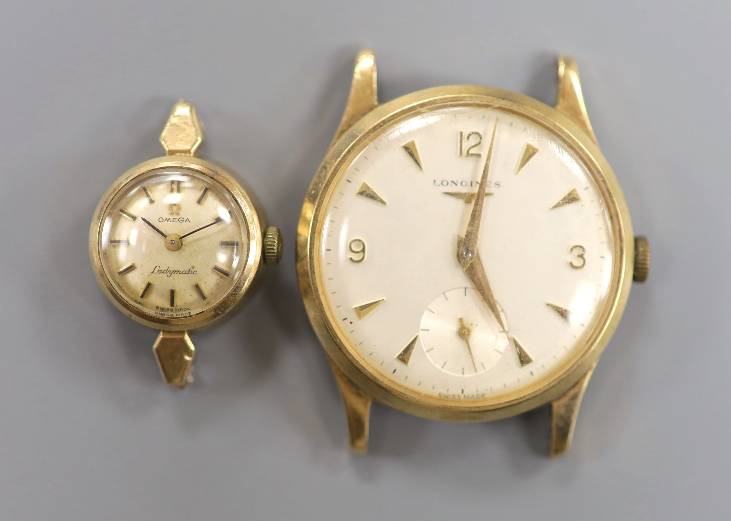 A gentleman's 9ct gold watch Longines manual wind wrist watch (no strap) and a lady's yellow metal Omega Ladymatic wrist watch (no strap), gross weight 39.5 grams.